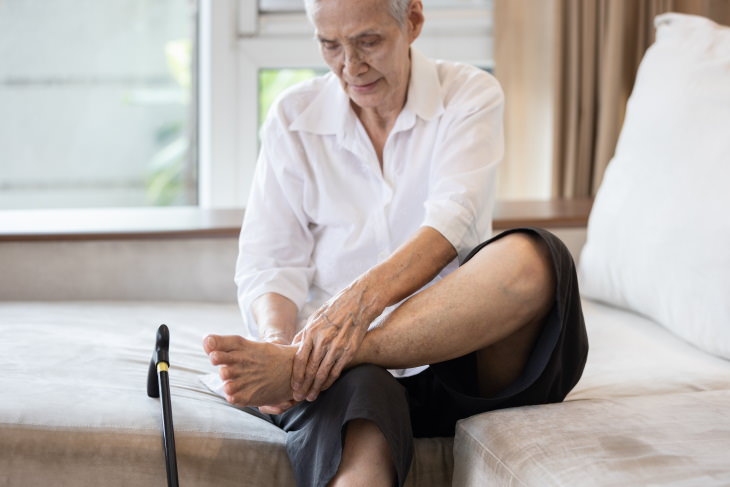 Cold Feet Causes and Remedies woman sitting and hold her foot