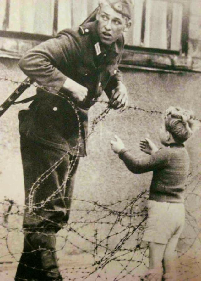 Historical Photos a German soldier going against direct orders to help a young boy cross the newly formed Berlin Wall after being separated from his family, 1961