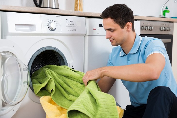 Laundry Tips Towels, man loading washing machine