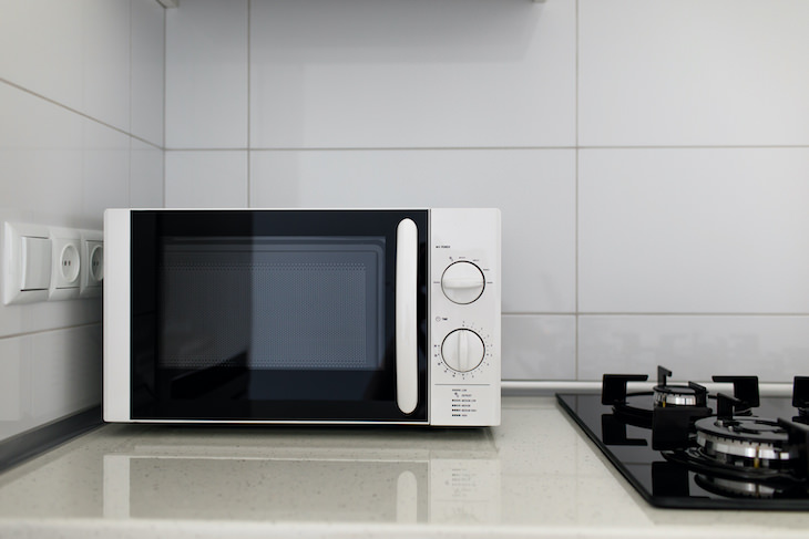  Habits That Shorten Your Microwave’s Lifespan, microwave next to hob