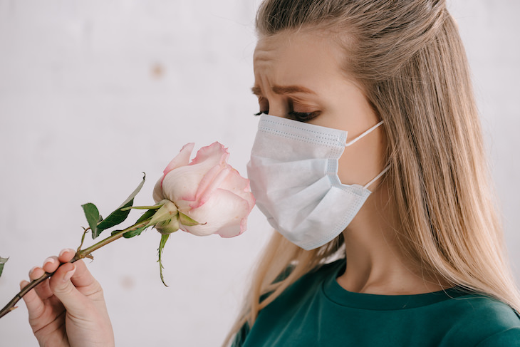 Subtle Sign You Might’ve Already Had Covid-19, woman with face mask smelling a flower