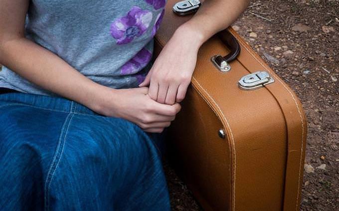 woman leans on suitcase