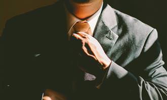 Man in suit straightening tie