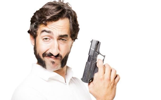 man smirking with gun