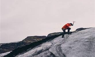 man climbs snowy mountain