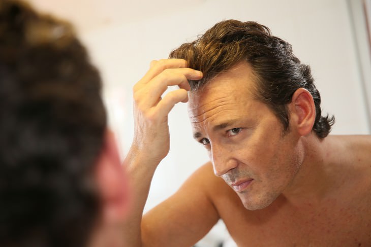 Health Benefits of Rosemary man examining his hairline 