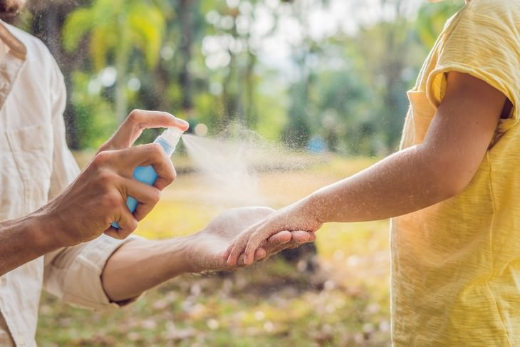 Health Benefits of Rosemary woman applying bug repellant spray on boy