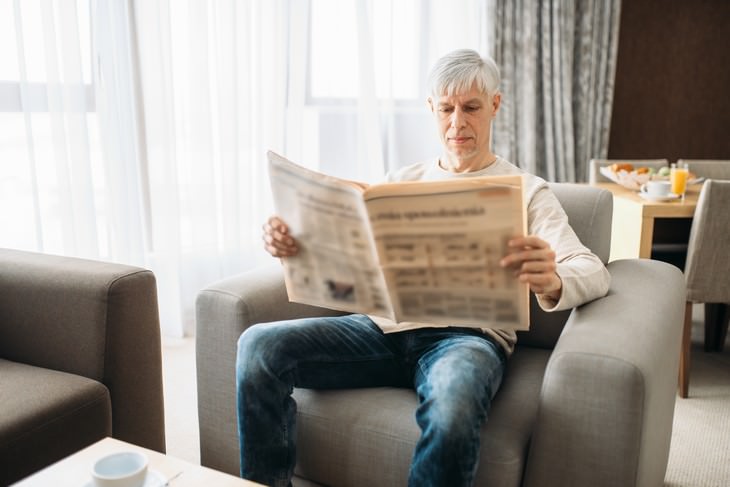 seniors health mistakes man sitting on couch reading newspaper