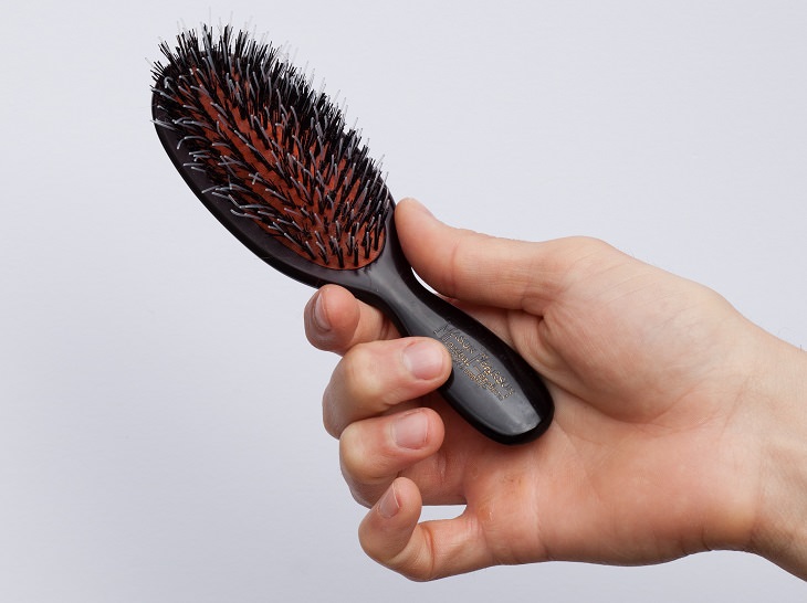 Tips to Help You Get Rid of Greasy Hair hand holding a brush