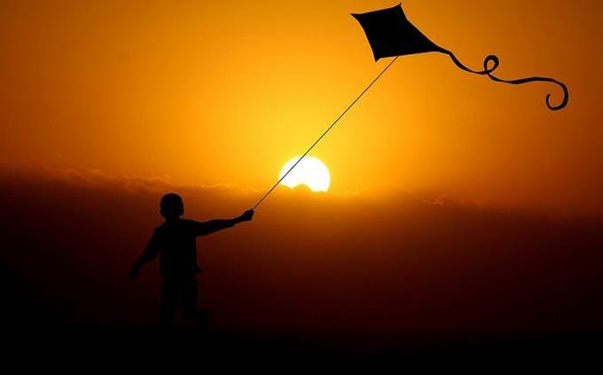 boy with kite at sunset