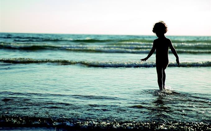 child on the beach standing in water