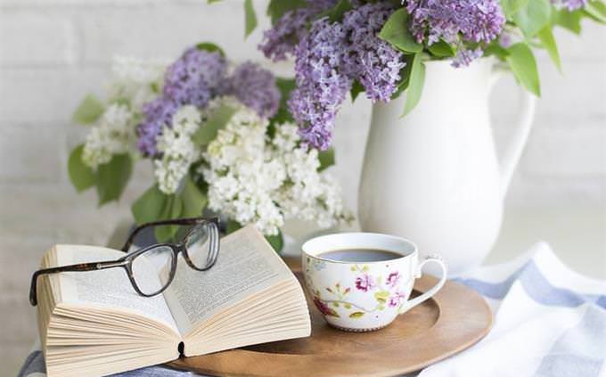 Coffee table with cup, book and flowers