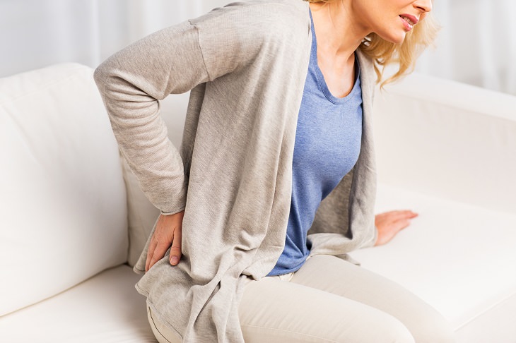 dangers of energy drinks woman lower back pain