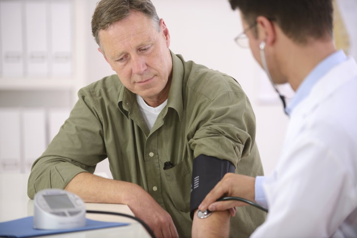 CBD oil health benefits doctor measuring a man's blood pressure