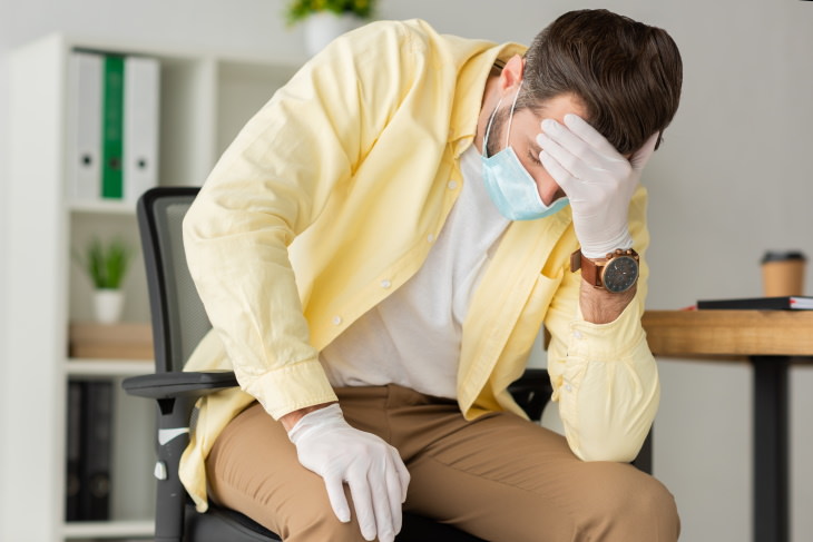 Long Term Health Consequences of COVID-19 man not feeling good at work coronavirus