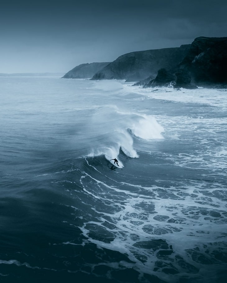 3. Um surfista solitário enfrentando o frio do inverno na costa norte da Cornualha, Cornualha, Reino Unido