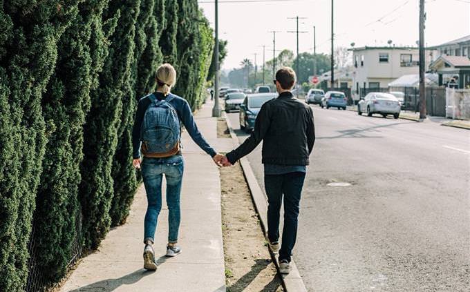 A couple holds hands and walks down the street