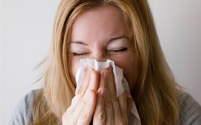 A woman blowing her nose