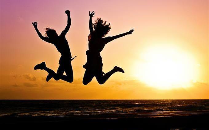 women jumping on the beach