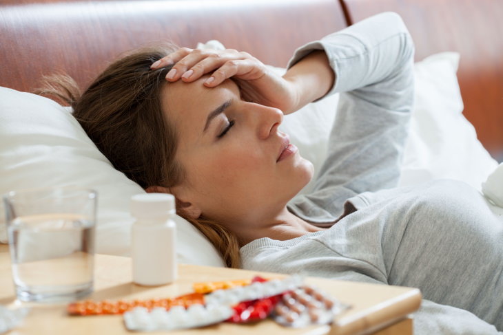 Signs of an Unhealthy Diet sick woman in bed with medication