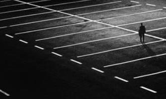 lone man in dark empty parking lot