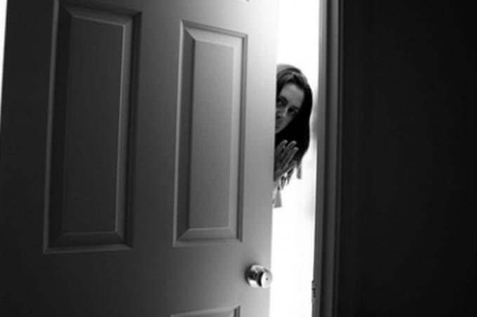 woman slowly opening door