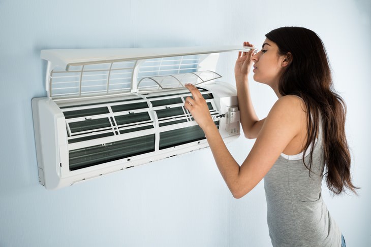 Is AC Increasing the Risk of Catching Coronavirus? woman checking AC filters