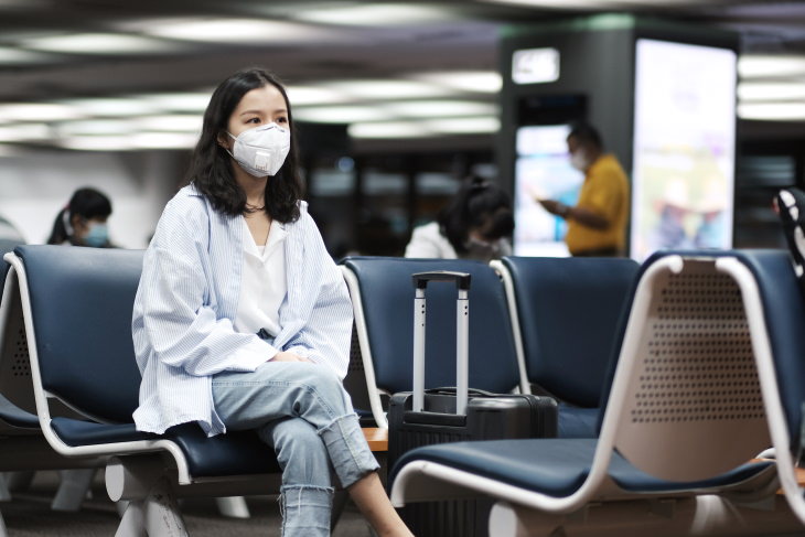 COVID-19: How to Fly Safely During a Pandemic woman wearing mask at the airport