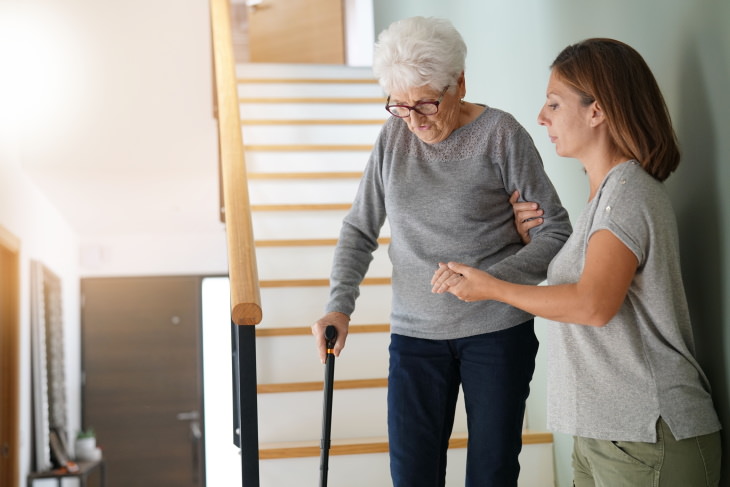 Hearing Loss Commorbidities Woman helping elderly lady go down the stairs