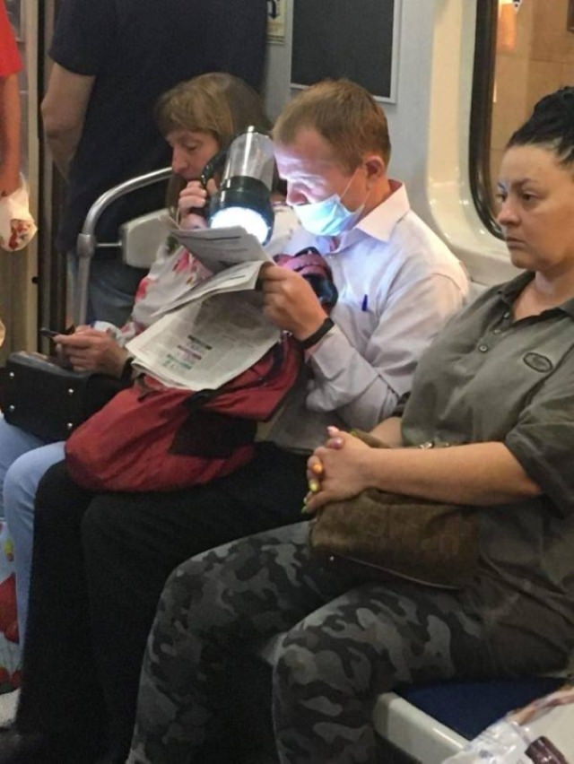 Weird Subway Passengers man in mask reading with flashlight