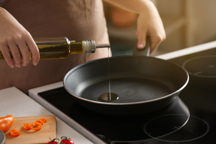 Olive vs. Vegetable Oil pouring oil into a frying pan