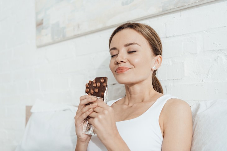 Nourishing vs Toxic Pleasure: What is the Difference? woman enjoying chocolate bar