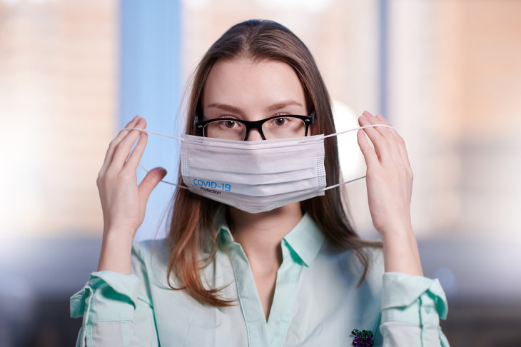 Face Masks and Dry Eye Syndrome woman putting on face mask