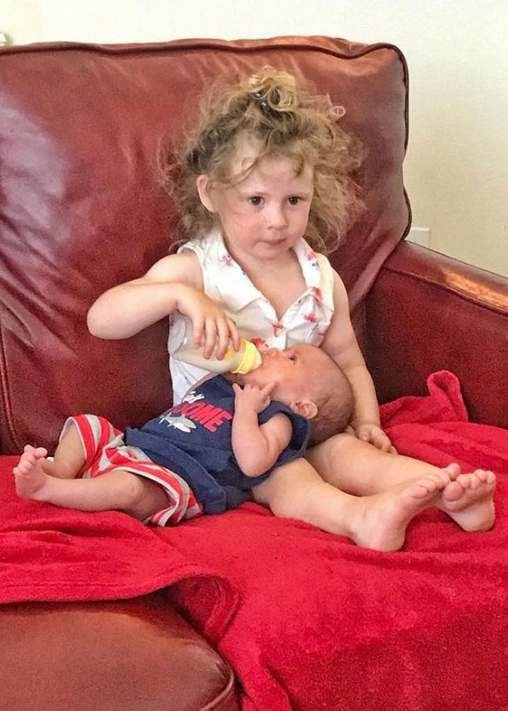 Awkward Family Photos sister feeds baby brother