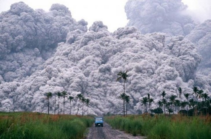 5. Una camioneta en Filipinas huyendo cuando el monte Pinatubo entra en erupción al fondo.