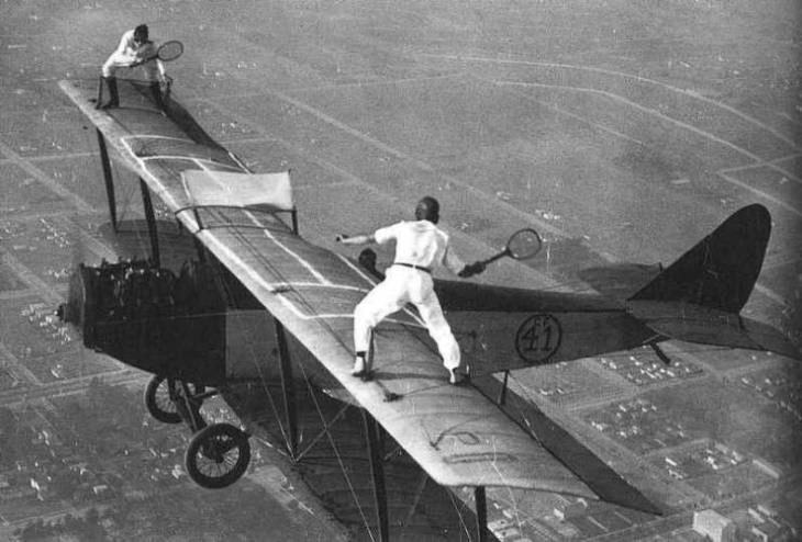 Vintage Photos Two men trying to play tennis on a bi-plane (1920)