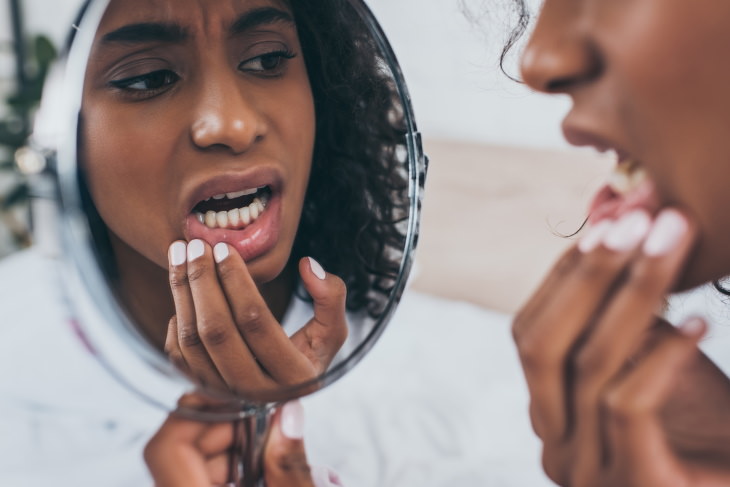 Excess Lemon Water Side Effects woman looking upset in front of the mirror