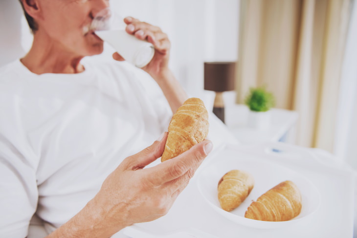 oily skin causes and tips man eating croissants and drinking milk