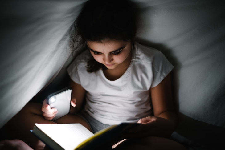 Insecure Apps girl reading a book with phone flashlight