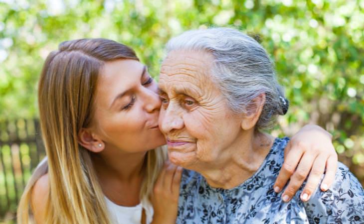 young woman kissing an elderly woman 