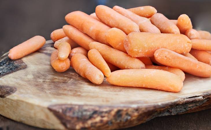 Dehydrated baby carrots on wooden cutting board 