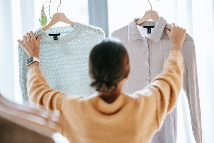 Speed Cleaning Tips woman holding up sweater and shirt