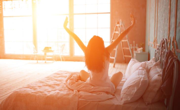 strong morning light waking a stretching woman 