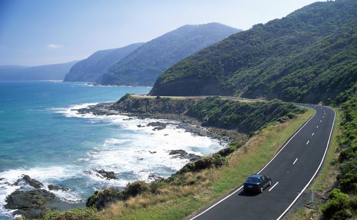 a passenger car driving by the seas side 