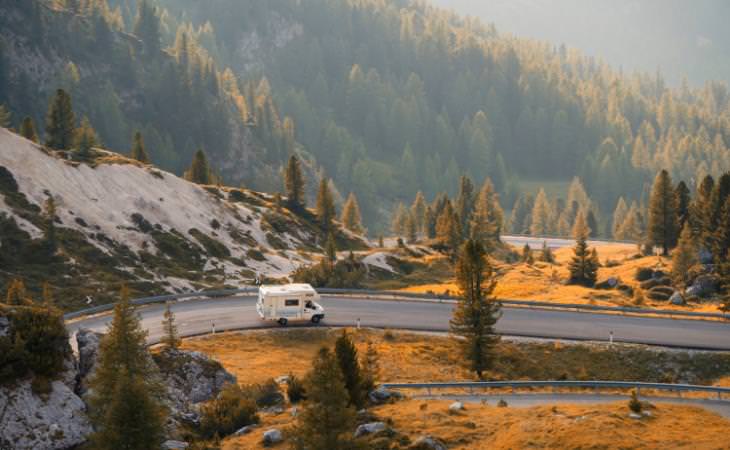 an RV driving in a meandering road in the snow 