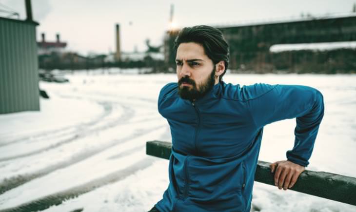 man wearing blue suit working out in the snow