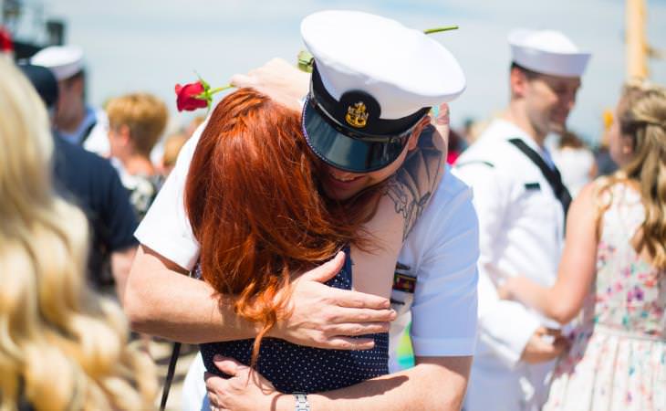 Navy soldier hugging a red hair woman