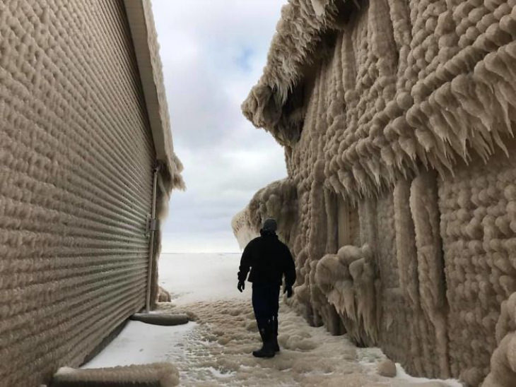 Lake Erie home Covered in ice, man standing in street