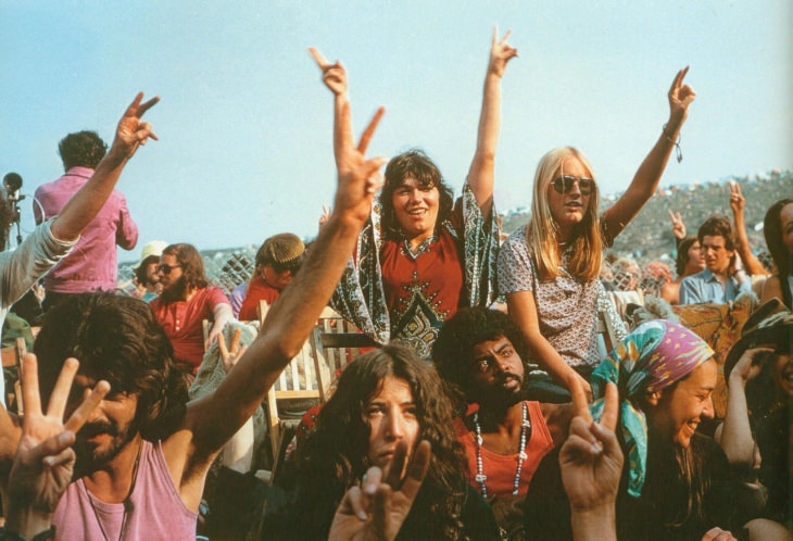 Woodstock people in the crowd doing a peace sign 