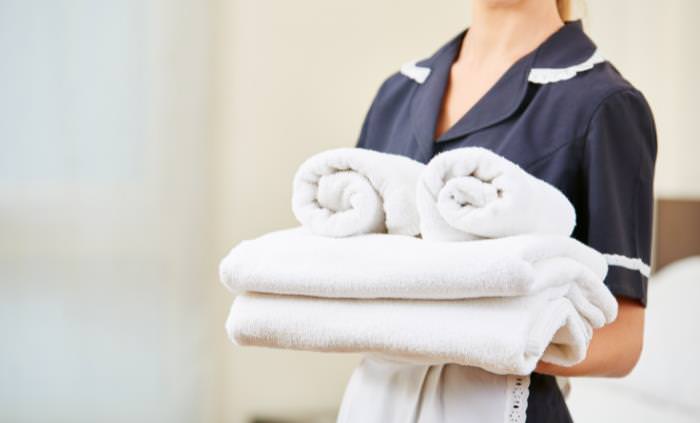housekeeper holding towels 